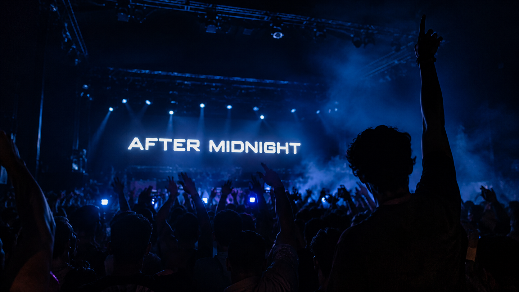 After Midnight stage screen glowing blue above a crowd
