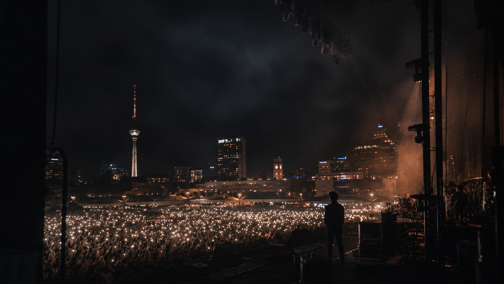 Berlin concert crowd glowing with phone lights at night
