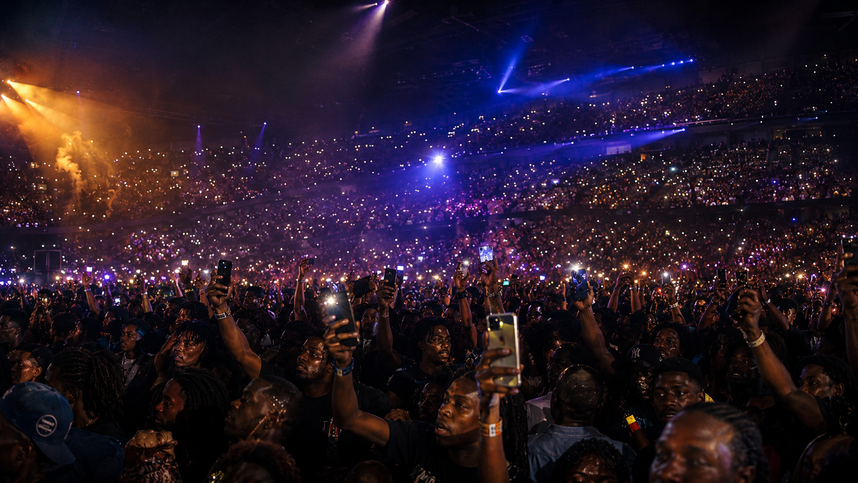 Large concert crowd holding phones under stage lights